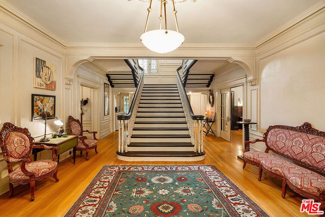 Grand foyer with a double-return staircase and pendant lantern.