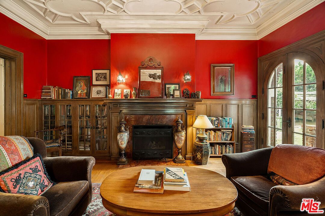 Mahogany-paneled library with red walls and original bookcases.